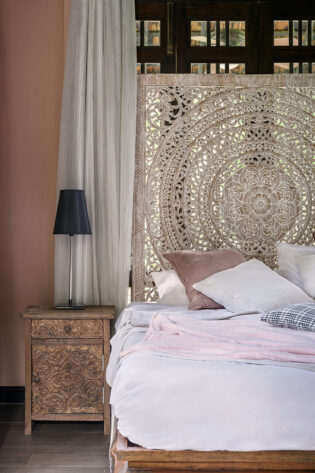 legant Queen Moroccan Headboard with a detailed carved pattern, serving as a breathtaking bedroom backdrop, enhances the room's exotic charm and sophistication.