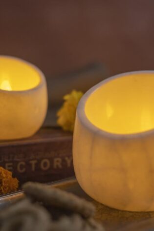 Rajasthani Twinkler candle holders in elegant white marble, casting a soothing light, nestled in a cozy home setting for a timeless appeal.