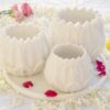 White marble Floret Candle Holders arranged on a tray amidst a sea of fragrant white petals and pops of red, embodying elegance for floor candle displays.