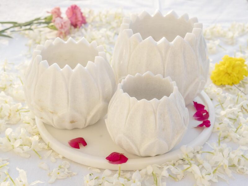 White marble Floret Candle Holders arranged on a tray amidst a sea of fragrant white petals and pops of red, embodying elegance for floor candle displays.