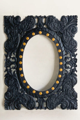 Black carved wood frame mirror with ornate detailing and gold accents, adding a luxurious touch to wall decor.